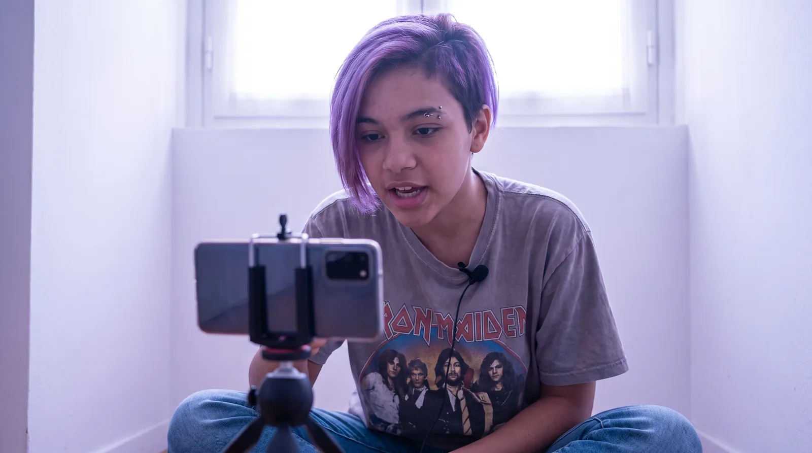 Creator recording a video at home with a smartphone and lavalier microphone